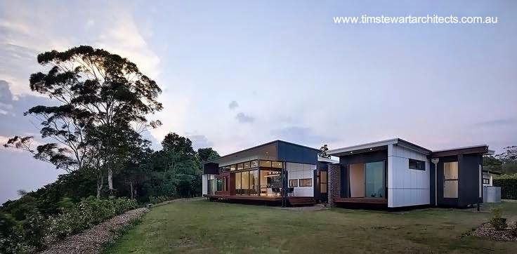 Hacia atrás la casa se abre y se ofrece el dominio visual del panorama Vista de los fondos de la casa de campo australiana proyecto Mountainview