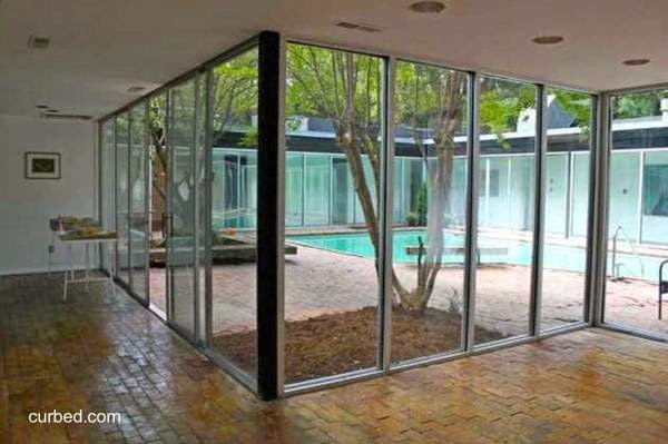 Muros vidriados hacia la abertura central con pileta de natación Interior de casa residencial Mid Century en Estados Unidos