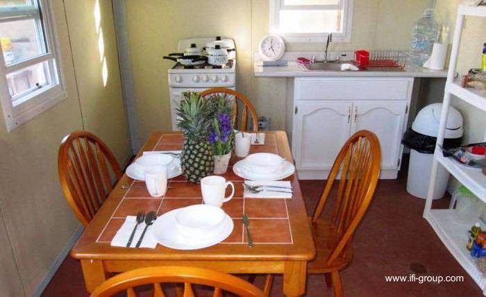 Vista del ambiente de uso común con instalación y mobiliario Cocina comedor de casa de bajo costo en México